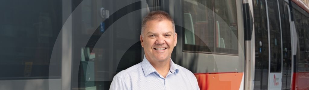A picture of Craig Lefoe of a background of Sydney train
