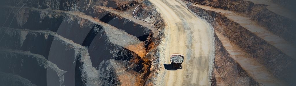 Banner for the 'Experts Reveal AI Initiatives and Challenges in Mining and Energy' article with a background of a haul truck in a mining location