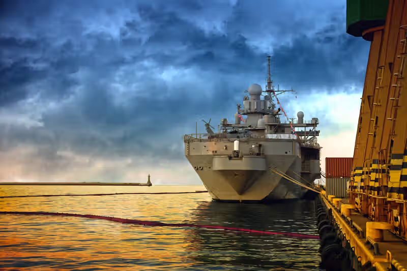 Defence banner. Image of a navy ship docked at port.