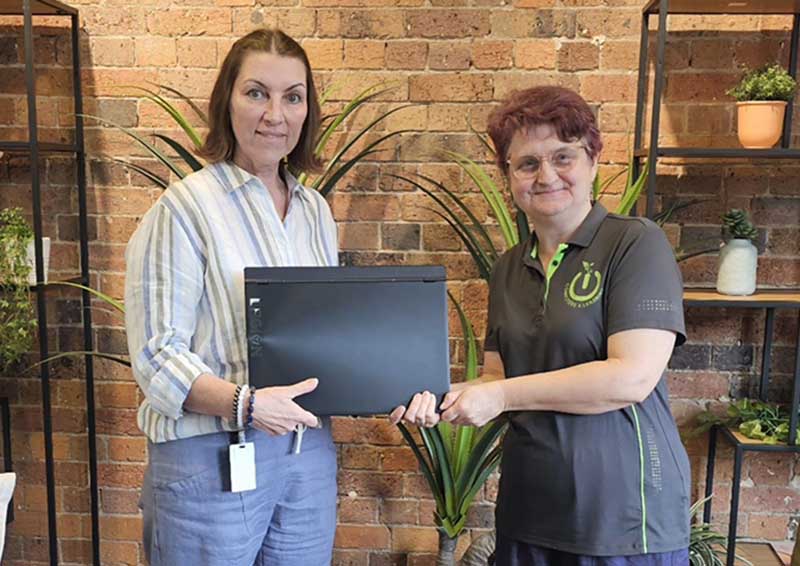 Tracey hands second hand laptops - skipping landfill - to the president of Computers4Learning