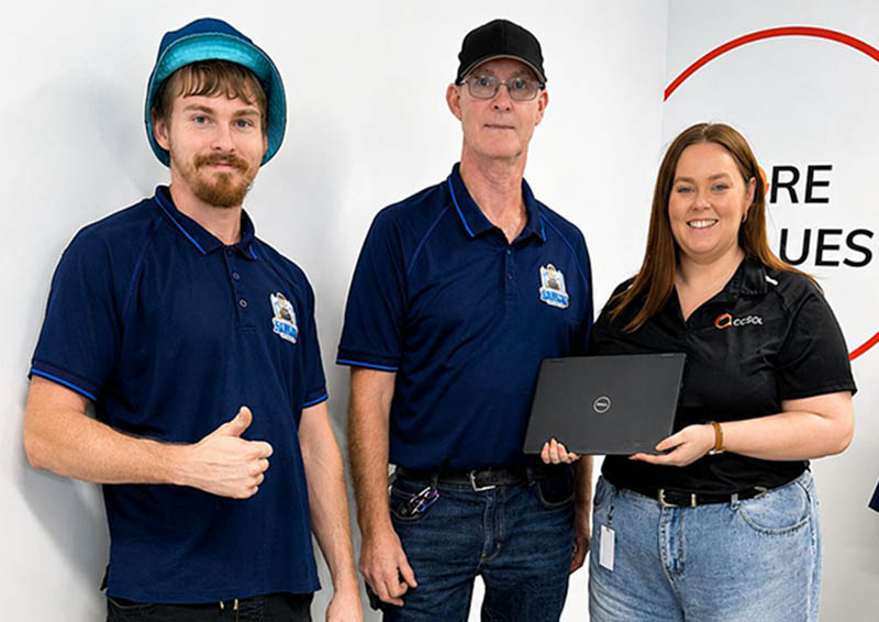 Jess hands second hand laptops to representatives from Sam's Spares. A part of COSOL's CSR initiatives