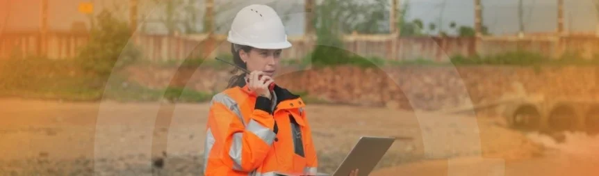 Banner of woman in safety gear surveying site and inputting data. Banner for a case study focusing on infrastructure provider
